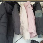Puffer and padded jackets in several colours hanging on a rack
