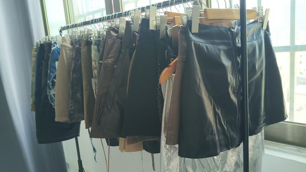 Denim skirts, PU-style skirts and shorts hanging on a rack
