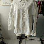White oversize shirt with a chest pocket displayed on a mannequin