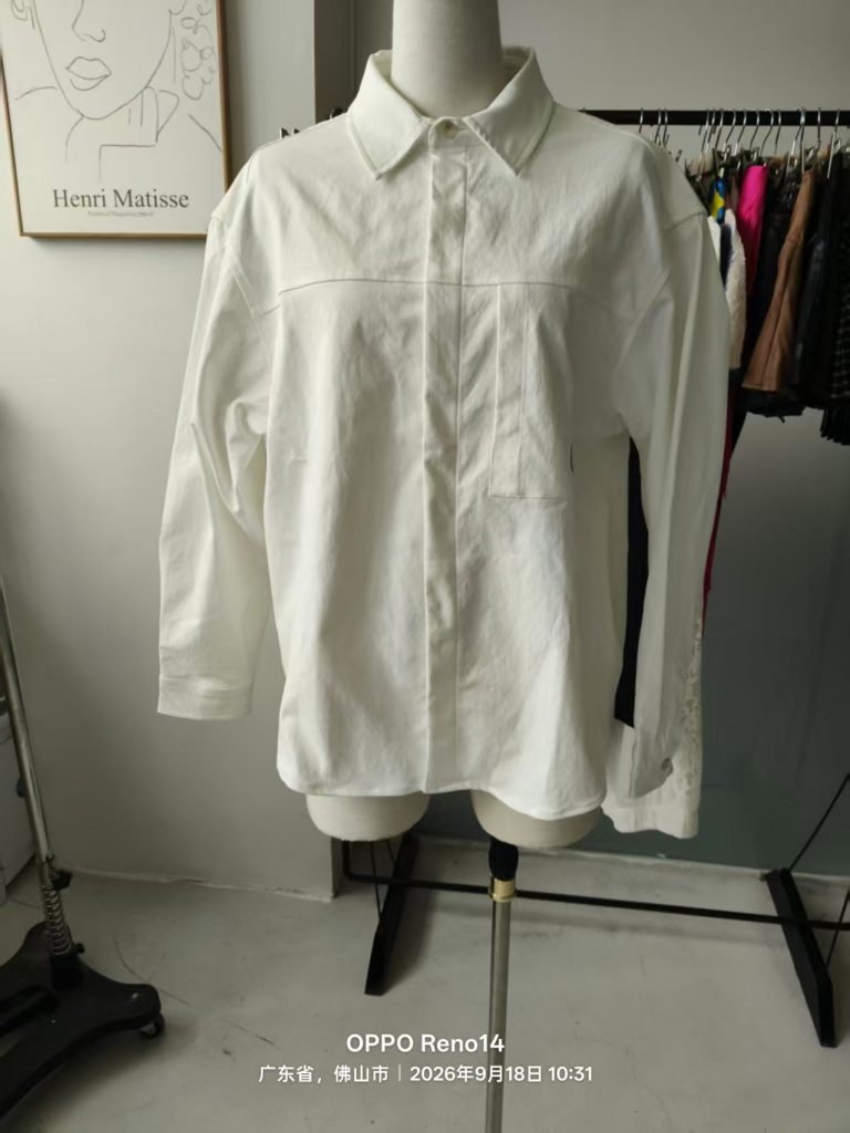 White oversize shirt with a chest pocket displayed on a mannequin