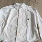 White poplin shirt laid flat on a table, front view